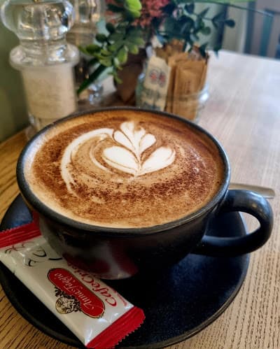 Croissant and cappuccino on a dark tabletop